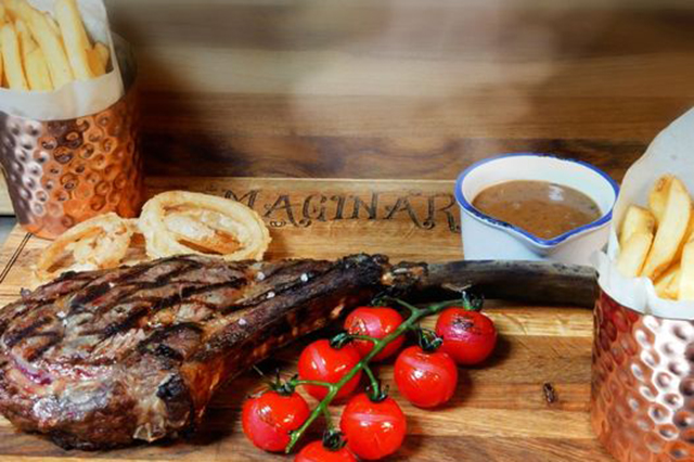 Image of steak, chips and tomato on a vine